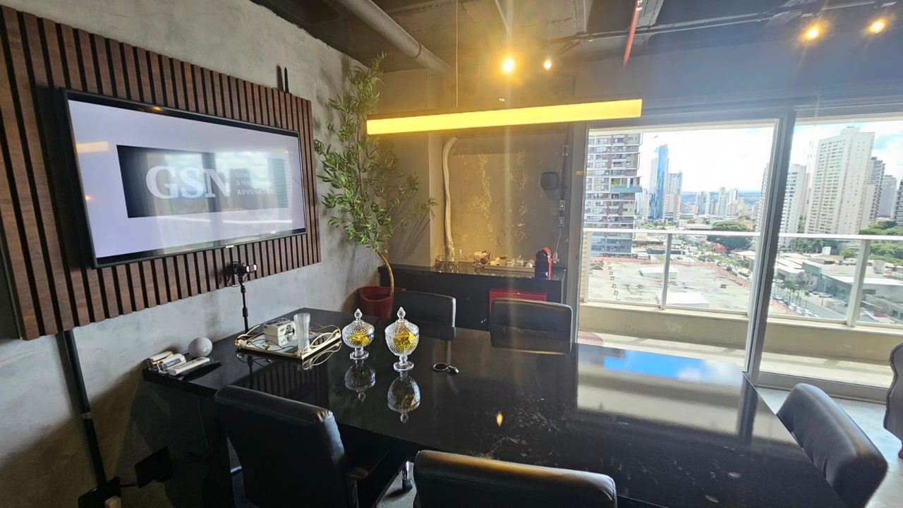 Mesa de reuniões com iluminação dourada e vista da cidade